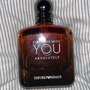 Stronger With You Absolutely från Emporio Armani - Säljer en elegant parfymflaska av Stronger With You Absolutely från Emporio Armani. Full flaska med 100ml kanske 5-8 sprej använden, men nästan helt ny annars och perfekt för att få uppmärksamheten i rummet 👃 