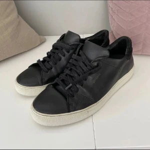 Svarta sneakers med vit sula - Snygga svarta arigato skor i storlek 40. Skick 9/10 och ser väldigt fräscha ut. Säljer för endast 599kr och kan pruta vid snabb affär!
