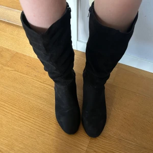 Svarta mockastövlar med dragkedja - Snygga svarta stövlar i mocka med dragkedja på sidan. De har en rund tå och en låg klack, perfekta nu till sommar.🥰(dom har lite slitage bak vid hälen)