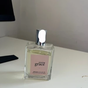 Amazing Grace parfym - En elegant parfym från Philosophy med namnet Amazing Grace. Flaskan är fyrkantig och genomskinlig med en rosa etikett. Den har en silverfärgad spraykork. Doften är känd för sin fräscha och blommiga karaktär.