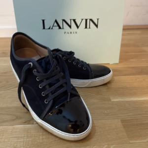 Mörkblå sneakers från Lanvin - Snygga mörkblå sneakers från Lanvin med ovandel i mocka och lackad tå.  Pris går att diskutera vid snabb affär, lägg ett bud så ser vi om jag godkänner det annars!