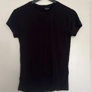 Svart basic t-shirt från Gina Tricot - En svart soft touch t-shirt från Gina Tricot i storlek L. Trivdes ej i storleken därav är den bara använd några fåtal gånger. Står ej för frakten.