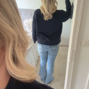 Ljusblå bootcut jeans med fickdetaljer - Säljer ett par ljusblå jeans med bootcut-modell och snygga fickdetaljer bak. Jeansen har låg midja och klassisk femficksdesign. Materialet är mjukt denim som sitter skönt och ger en avslappnad vibe. Jag säljer dom då dom är för stora och för långa på mig