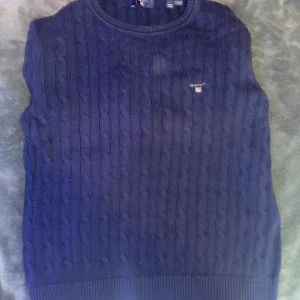 Mörkblå kabelstickad tröja från Gant! - 📍( Tveka inte på att slänga ett dm)📍Kabelstickad mörkblå tröja från Gant med rund halsringning och broderad logga på bröstet. Tröjan har långa ärmar och ribbade muddar vid ärmslut och nederkant. Perfekt för dig som gillar klassisk och stilren look. Precis för dig som vill Resella. OBS Priset är inte hugget i sten!🚀