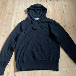 Svart stickad hoodie William de Faye - Svart stickad kashmir hoodie från William de Faye med huva och snörning. Tröjan har lång ärm och ribbade muddar och i storlek M. Hoodien är snålt använd med få tecken på användning det ens skulle vara att den är lite nopprig. Nypris ligger runt 1500 men jag begär 500 priset är dock inte hugget i sten och jag är villig att förhandla