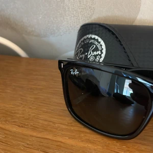 Svarta Ray-Ban Wayfarer solglasögon - obs!helt nya Klassiska svarta Ray-Ban Wayfarer solglasögon med glansig båge och mörka glas. Snygg och tidlös design med Ray-Ban-logga på både glas och skalmar. Kommer med original svart fodral. Perfekta för dig som vill ha en ikonisk look.