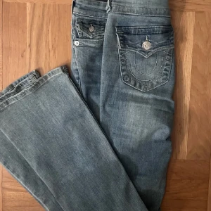 True Religion ljusblå jeans - Säljer dessa snygga true religon byxor i strl 26. Lite slitna längst ner. Lånade bilder.