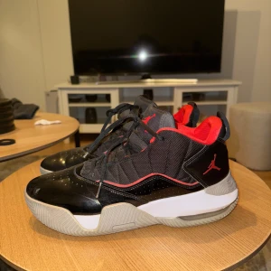 Svarta och röda Nike Air Jordan sneakers - Snygga Nike Air Jordan sneakers i svart och rött med vit sula. Skorna har klassisk Jumpman-logga, snörning och en mix av textil och syntetmaterial. Röd insida och detaljer ger en fet kontrast till den svarta ovandelen. Perfekta för dig som gillar streetstyle.