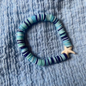 Sea paradise🐬 - Superfint armband med platta pärlor i olika blå nyanser och en vit sjöstjärna som detalj. Armbandet har ett strandigt vibe och är elastiskt så det passar de flesta handleder. Perfekt accessoar för dig som älskar havet och coola färger.