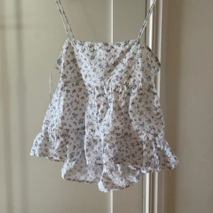 Somrigt linne  - Ett blommigt linne med öppen rygg i storlek XL, kommer från Gina tricot.Jag har vanligtvis storlek M/L på tröjor och de sitter bra på mig. Använt endast en gång.