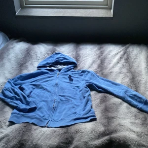 Ralph lauren zip hoodie - En blå zip tröja från Ralph lauren som passar perfekt på sommar kvällar. Inga defekter som är märkvärdiga och sitter som S