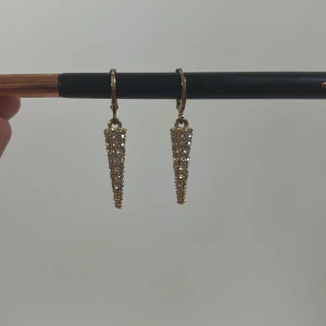 Guldglittriga örhängen - Snygga guldglittriga örhängen med en avsmalnande design. Perfekta för att ge en touch av glamour till din outfit. De hänger elegant och fångar ljuset vackert. Skriv först om ni skulle vilja köpa! ❤️