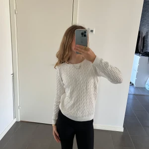 Vit stickad tröja från Basic You - Säljer en stilren vit stickad tröja från Basic You i ekologisk bomull. Tröjan har ett klassiskt flätmönster och långa ärmar, perfekt för en mysig look. Passar bra till både jeans och kjol. Hör av dig vid intresse! 🤍