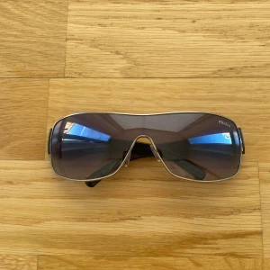 Svarta solglasögon från Prada - Snygga svarta solglasögon från Prada med en modern design. Jag säljer dem för att jag fick nya solglasögon som present. Dem passar perfekt inför sommaren. Har använt dem 3-5 gånger eftersom jag var utomlands.           Pris kan diskuteras.