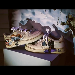 Unika Nike Air Force med konstnärlig design - Säljer ett par unika Nike Air Force med handmålad konstnärlig design. Skorna har en bas i beige med färgglada illustrationer och vita snören. Perfekt för dig som vill sticka ut med en personlig stil.