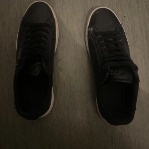 Svarta sneakers från Jack & Jones - Snygga svarta sneakers från Jack & Jones med vit sula och klassisk snörning. Perfekta för en stilren look. Diskret logga på sidan och bekväm passform.