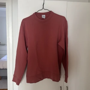 Röd sweatshirt från Zara - Säljer en stilren röd sweatshirt från Zara. Tröjan har en klassisk rund halsringning och långa ärmar. Perfekt för en avslappnad look. Tillverkad i Portugal.