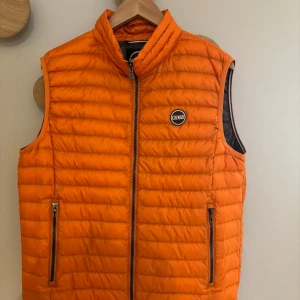 Orange dunväst från Colmar - Snygg orange dunväst från Colmar med dragkedja och två fickor framtill. Nypris 2300 men säljer för 1500. Skriv om frågor🩷