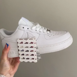Vita Nike Air Force 1 sneakers - Säljer ett par klassiska vita Nike Air Force 1 sneakers. Skorna har en stilren design med snörning och rund tå. Aldrig använda 