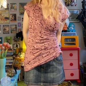 Söt topp indiska - Blommig kortärmad topp från indiska i storlek S. Veckad på ena sidan, markerar midjan fint. Hör av dig om du undrar något