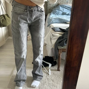 Grå jeansbyxor - Säljer ett par grå jeansbyxor med normal passform och hög midja. Byxorna har klassisk femficksdesign och stängs med knapp och dragkedja. Perfekta för en avslappnad stil.