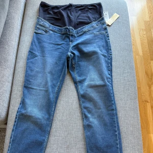 Ny Lindex blåa mammajeans, storlek 46 - 🫧Ett par blåa mammajeans med en mörkblå mudd upptill.  🫧Mjuk och bekväm material. 🫧Storlek 46 🚭Djurfritt och rökfritt hem.