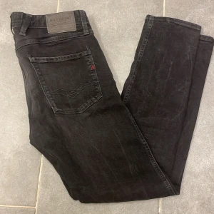 Svarta jeans från Replay - Snygga svarta jeans från Replay med klassisk femficksdesign och en diskret logga på bakfickan. Perfekta för en stilren look. Skick 8/10