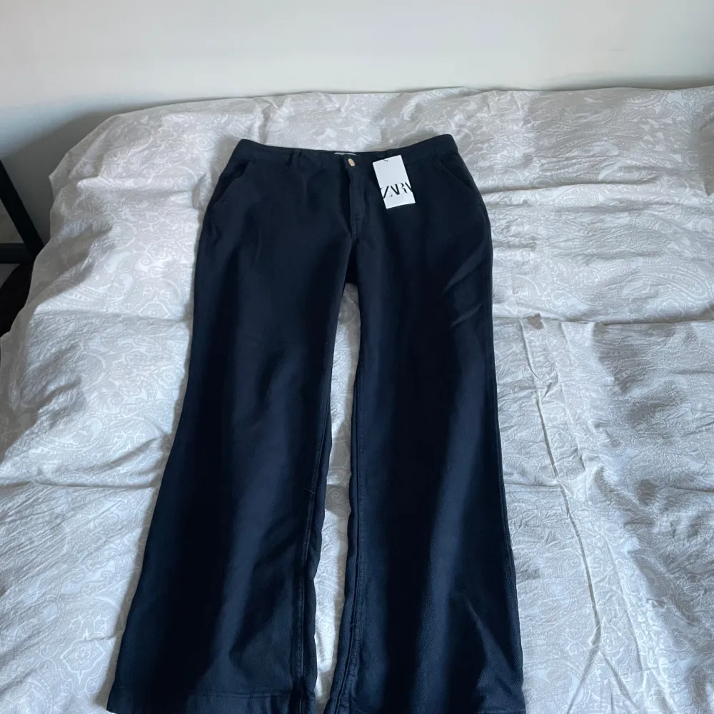 Snygga svarta byxor från Zara med en klassisk design. De har en rak passform och är tillverkade i ett bekvämt material. Perfekta för en stilren look.. Farkut & Housut.