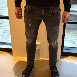 Grå replay jeans med slitningar - Snygga grå jeans med slitningar och en tight passform. De har en klassisk femficksdesign och dragkedja. Perfekta för en trendig look.