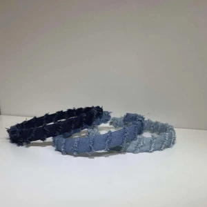 Jeansdiadem i tre färger - Snygga diadem i jeansmaterial med fransiga kanter. Finns i både mörkblå och ljusblå nyans. Perfekt för att ge en avslappnad och trendig touch till din outfit.                                                 Skriv gärna innan köp vilken färg ni är intresserade av att köpa.