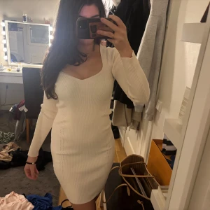 Vit ribbad klänning - Säljer en stilren vit ribbad klänning med v-ringning och långa ärmar. Från chiquelle i strl xs/s,aldrig använd