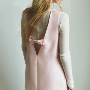 ljusrosa cocktailklänning med rosett - så söt ljusrosa kort klänning i satin med en fin rosett i ryggen. så snygg till fest, har endast haft en gång och tvättat sen dess. den är fortfarande glittrig och rosetten sitter bra i ryggen🩷