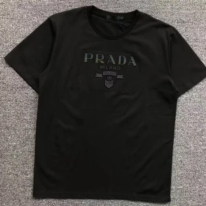 Svart t-shirt från Prada - Snygg svart t-shirt från Prada med diskret tryck på bröstet där det står 'PRADA MILANO'. Klassisk rund halsringning och korta ärmar. Perfekt för en stilren och trendig look.