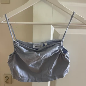 Ljuslila croppad linnetopp från Weekday - Säljer en ljuslila croppad linnetopp från Weekday med tunna axelband och rynkade sidor. Perfekt för varma dagar och enkel att matcha med jeans eller kjol.