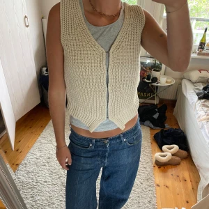 Beige stickad väst från Weekday - Säljer en beige stickad väst från Weekday i storlek XS. Västen har v-ringning, bred ribbad kant nedtill och är öppen framtill utan knappar eller dragkedja. 