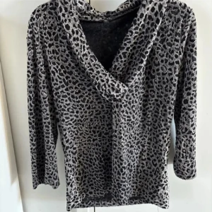Leopardmönstrad långärmad tröja från Flash - Säljer en snygg långärmad tröja från Flash med leopardmönster i svart och grått. Tröjan har en lösare passform och en bred, draperad krage. Perfekt för dig som vill sticka ut lite extra.