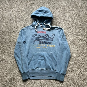 Superdry hoodie - Tja, säljer nu denna snygga Superdry hoodien! Synligt använd men har inga fläckar eller hål, endast tvättad. Nypris 800kr. Pris diskutabelt. Hör av dig vid frågor👍