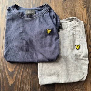 Två T-shirts från Lyle & Scott - Säljer ett paket med två Lyle & Scott T-shirts. En marin blå och en grå. De har mest legat i garderoben och därför så skrynkliga. Den blåa har en liten fläck däruppe. Det går att köpa separat. Skriv till mig om ni har frågor!