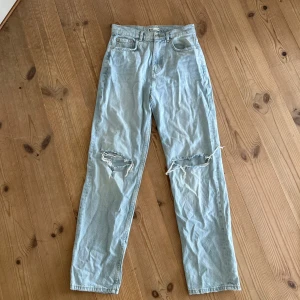 Ljusblå jeans med hål på knäna från ginatricot  - Ljusblå raka jeans från ginatricot perfect jeans med slitna hål på båda knäna. Normal passform och dragkedja samt knapp i midjan. Oanvända💕