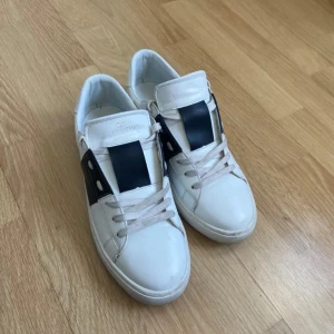 Vita sneakers från Valentino med svart detalj - Snygga vita sneakers med bred svart rem över mitten och vita snören.💕