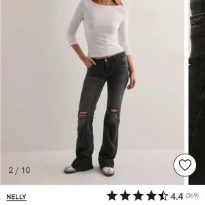 Mörk grå bootcut jeans med hål på knäna. - Säljer ett par mörk grå bootcut jeans med hål på båda knäna från Nelly. Passformen är normal och benen är utsvängda nertill och low waist.  Nästan helt nya har använt några få gånger. Storlek 32. Köpte för 699kr säljer för 300kr.  Pris kan diskuteras.
