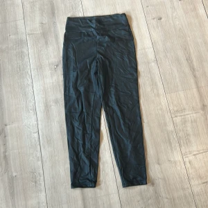 Svarta skin byxor - Säljer ett par svarta skin byxor med hög midja. De är tighta och har en enkel, stilren design utan synliga detaljer. Perfekta för lite fina tillfällen eller en bättre look på jobbet .