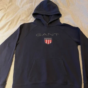 Marinblå Gant hoodie - Säljer min marinblåa Gant hoodie i storlek 176. Skulle säga att den passar som en XS/S. Tröjan är knappt använd och inga defekter förekommer. Skriv för fler bilder. 