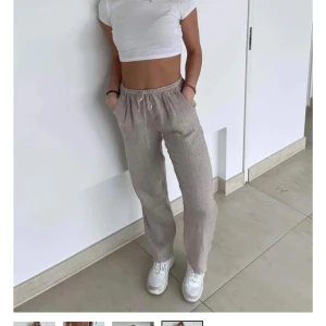 Beige linnebyxor  - Säljer ett par beige linnebyxor med avslappnad passform och elastisk midja med dragsko. Byxorna har raka ben och sidfickor, perfekta för en chill och stilren look. Nästan aldrig använda. Regular längd/ Extra längd