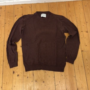 Brun stickad tröja från These Glory Days - Säljer en brun stickad tröja från These Glory Days. Tröjan har rund halsringning, lång ärm och ett diskret rutmönster i strukturen. Perfekt för lager-på-lager och enkel att matcha med jeans eller chinos.