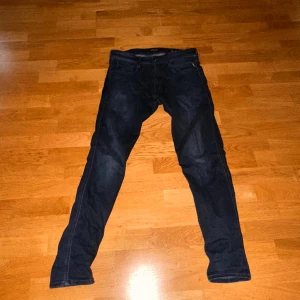Mörkblå jeansbyxor Replay Anbass - Säljer ett par mörkblå Replay Anbass jeans med klassisk femficksdesign och smal passform. Byxorna har svarta detaljer vid linningen och är tillverkade i ett stretchigt denimtyg för extra komfort. Perfekta för dig som gillar stilrena jeans! Köpta för 1700kr. Pris går att diskutera 