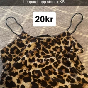 Leopardmönstrad linnetopp XS - Snygg linnetopp med leopardmönster och tunna svarta axelband. Toppen har en beige och brun bas med svarta fläckar, perfekt för dig som vill sticka ut. Lätt och luftig känsla, passar till många olika stilar.