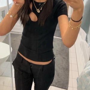 Svarta lågmidjade byxor - Säljer ett par svarta lågmidjade byxor med bootcut och klassisk look. Byxorna har fickor fram och bälteshällor, perfekta till en trendig outfit. Materialet känns som bomull eller polyester och passformen är normal. Ny pris är 499kr 