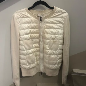 Moncler cardigan - Supersnygg vit cardigan jacka från Moncler med quiltad framsida, två fickor och dragkedja. Den har nån rosa fläck på insidan men inget som syns på utsidan eller på, självklart äkta kan leta fram kvitto och har dustbagen kvar! ❤️