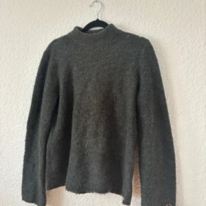 Grön  stickad tröja med halv polo krage  - Mysig grön stickad tröja  med halv polo krage  lång ärm. Enkel och stilren modell som är perfekt att slänga på sig när det är kallt ute. 